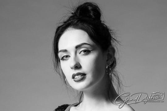 Black-and-white studio headshot of Lana West with her hair pinned up.